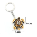Tribal style resin turtle keychain with sun face engraving and 3.9cm dimensions - Red Brown