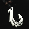 Detailed view of Maori style resin fish hook pendant with tribal carvings on black cord - Fish Hook Style (A) / White