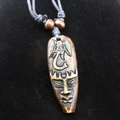 Détail d'un pendentif tribal en résine avec éléphant sculpté et masque africain gravé - Style Totem Éléphant / Marron