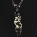 Close-up of vintage resin dragon totem pendant with intricate carving on a black cord - Black