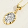 Two-tone San Judas oval pendant necklace with golden heart connector on a stone surface - Ellipse