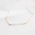 Detalle macro de collar de cristal blanco natural envuelto en alambre chapado en oro 14K - Dorado