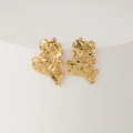 Irregular gold earrings with hammered lava texture on a white display stand - Gold