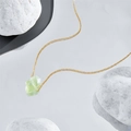 Detailaufnahme einer 14 Karat vergoldeten Kette mit grünem Naturstein auf Spiegelhintergrund - 14k / Grün