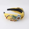 Detail of a yellow baroque headband featuring handmade beads and blue floral embroidery - Yellow
