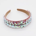 Detailed close-up of pink velvet headband with shimmering rainbow AB crystal flower pattern - Red