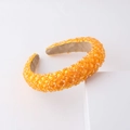 Gros plan d'un serre-tête orange fait main avec une texture en maille de cristal 3D - Orange