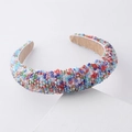 Close-up of vibrant crystal beads and soft tan velvet lining on a fashion headband - Colorful Crystal