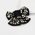 Détail du nœud papillon en velours noir avec perles blanches et strass brillants - Style Strass Noir