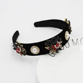 Detailed view of baroque headband with red gems and pearls on black velvet fabric - Black