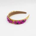 Dettaglio di un cerchietto in raso dorato con strass rosa e blu scuro a forma di fiore - Giallo