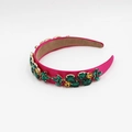 Dettaglio del cerchietto in raso rosso rosa con decorazioni a foglia di strass - Rosso