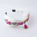 Détail d'un serre-tête en satin blanc avec cristaux fuchsia et fleurs de strass - Blanc