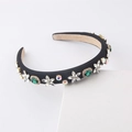 Dettaglio del cerchietto imbottito nero con cristalli color smeraldo e fiori di strass - Nero