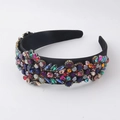 Detailed view of colorful rhinestones on a black velvet wide headband with baroque style - Colorful