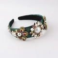 Close-up of Baroque headband with colorful crystals and pearls on deep green fabric base - Green