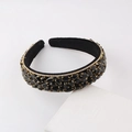 Detalle de diadema de terciopelo de lujo con cristales negros y engastes dorados finos - Negro