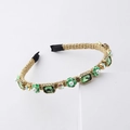 Detalle de diadema trenzada dorada con cristales verdes y perlas blancas de lujo - Verde