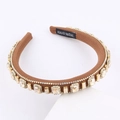 Detailed macro of a brown knit headband featuring champagne square gems and white rhinestones - Brown