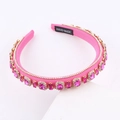 Detailed macro view of pink fabric headband featuring hand-sewn crystals and handmade label - Hot Pink