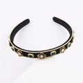 Detailed view of vintage velvet headband with golden metal flowers and rhinestone edges - Elegant Black (E)