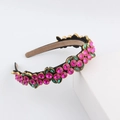 Close-up of pink crystals and green marquise gems on a baroque style wide headband - Pink And Green (B)