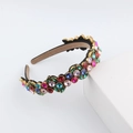 Macro view of luxurious baroque headband featuring multi-color crystals on a gold base - Multicolor Mix (D)