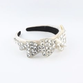 Macro-opname van beige satijnen haarband met gedetailleerde strass-strikjes - Beige