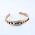 Dettaglio del cerchietto in raso beige con velluto marrone e strass luccicanti - Stile Beige