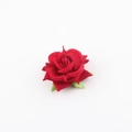Detail of a deep red artificial fabric rose with layered petals and green leaves - Red