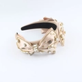 Detailed view of champagne satin headband with pearls, rhinestones, and metal accents - Champagne Vintage Bow Style / Champagne