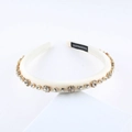 Detail of a handmade cream padded satin headband with sparkling rhinestones in gold claw settings - Off-White With Clear Rhinestones (I)