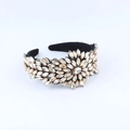 Detailed close-up of Baroque padded headband with champagne rhinestones on black velvet - Champagne