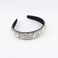 Close-up of baroque headband featuring intricate clear crystals on a black base - White