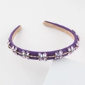 Close-up of purple fabric headband with sparkling crystal flowers and gold chain detail - Purple (E)