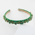 Detailed macro view of luxury green velvet headband with emerald gemstones and golden trim - Green (E)