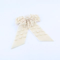 Detail of cream velvet bow hair clip with embedded white faux pearls for elegant styling - White