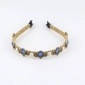 Close-up of vintage gold metal headband with blue teardrop gems and white pearls - A Blue