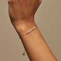 Primer plano de la pulsera dorada con letras MAMA y circonitas en la muñeca - Pulsera de Letras MAMA (SL0125)
