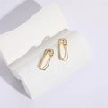 Golden safety pin earrings with pave cubic zirconia on a minimalist white stone pedestal - 14K Gold White Zircon