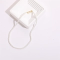 Collier élégant de perles blanches avec fermoir mousqueton doré sur support moderne - Modèle Long Fermoir Mousqueton