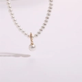 Détail du collier de perles avec pendentif en strass dorés et perle suspendue - Style Pendentif Perle
