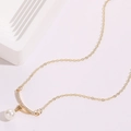 Detailed shot of golden necklace with a white pearl and sparkling star pendant decoration - Star Double Pendant Style