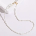 Élégant collier de perles blanches avec fermoir mousqueton doré sur support minimaliste - Modèle Fermoir Mousqueton en 8