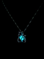 Detailansicht der leuchtend blau strahlenden Perle im katzenförmigen Metallanhänger - Cyan