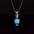 Dettaglio della collana con ciondolo ananas e pietra luminosa blu ghiaccio al buio - Luminoso Blu Cielo