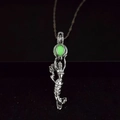 Detailed view of mermaid pendant with luminous green bead glowing in silver cage - Green