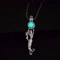 Macro detail of mermaid pendant with glowing teal luminous stone on a dark background - Light Blue Glow