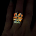 Nahaufnahme eines Punk-Totenkopfrings, der im Dunkeln hell orange und grün leuchtet - Einstellbar Offen / Altsilber Oranges Leuchten