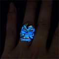 Detail eines leuchtenden Totenkopfrings mit blauer Fluoreszenz in dunkler Umgebung - Einstellbar Offen / Antik-Silber Blaues Leuchten